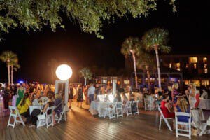Photo of fall launch event, illuminated signs, ring lights, signs, tables with white linen, flowers