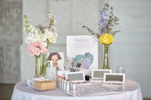 Photo of fall launch event, illuminated signs, ring lights, signs, tables with white linen, flowers