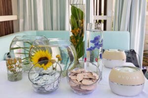 Photo of custom floral design, sunken flowers, tall vases, flat circle vases, sunflowers and skincare for a Blue Spark Event Design - Product Launch Miami