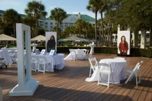 Photo of fall launch event, illuminated signs, ring lights, signs, tables with white linen, flowers