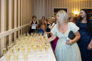 Photo of woman grabbing a glass of champagne