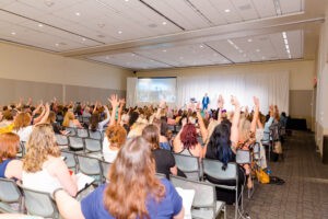 Photo of Attendees raising their hands while participating in a Hybrid Product Launch Training