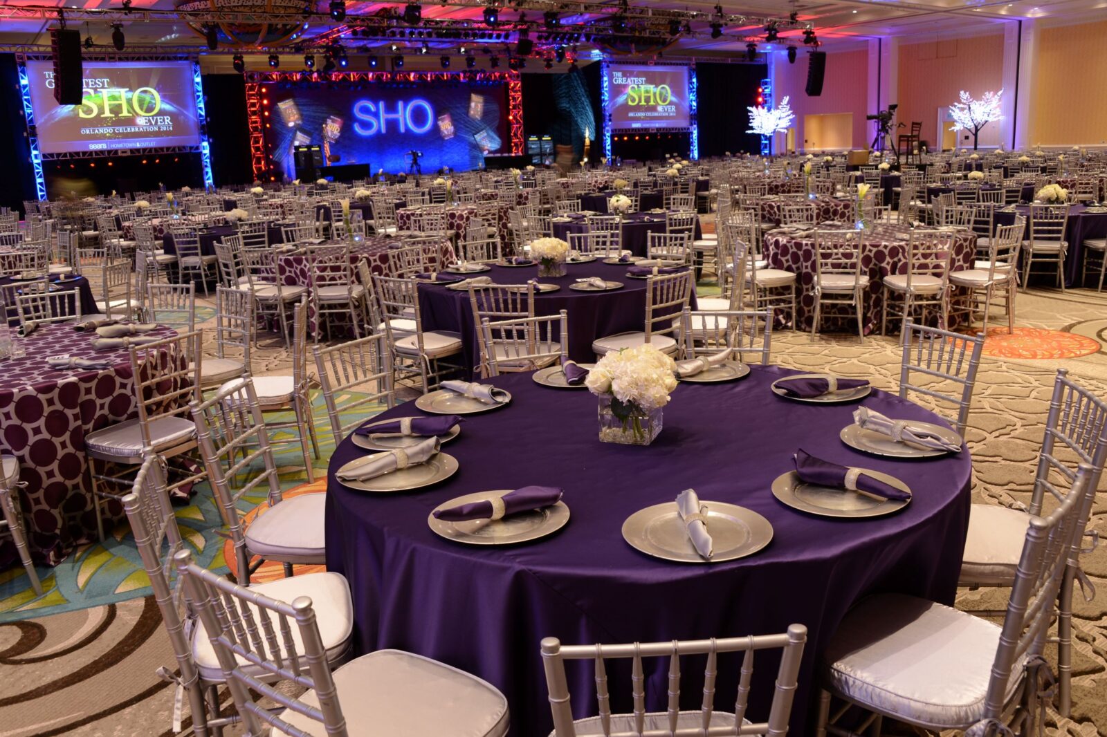 Photo of awards banquet, purple linen, silver chiavari chairs