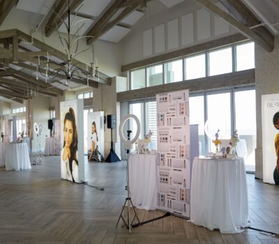 Photo of fall launch event, illuminated signs, ring lights, signs, tables with white linen, flowers