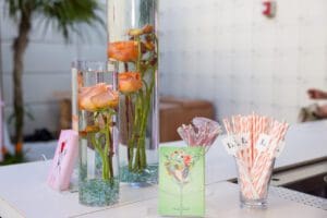 Photo of drink stirs, colorful straws, custom floral design sunken in water for a Blue Spark Event Design - Product Launch Miami