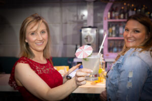 Photo of woman holding a drink with an umbrella for a Blue Spark Event Design - Product Launch Miami