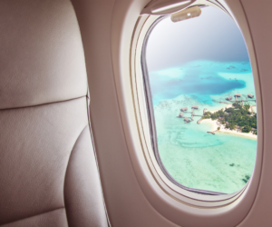 Airplane window with blue water